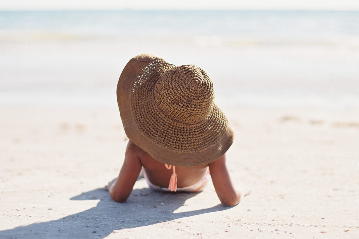 girl on beach with hat